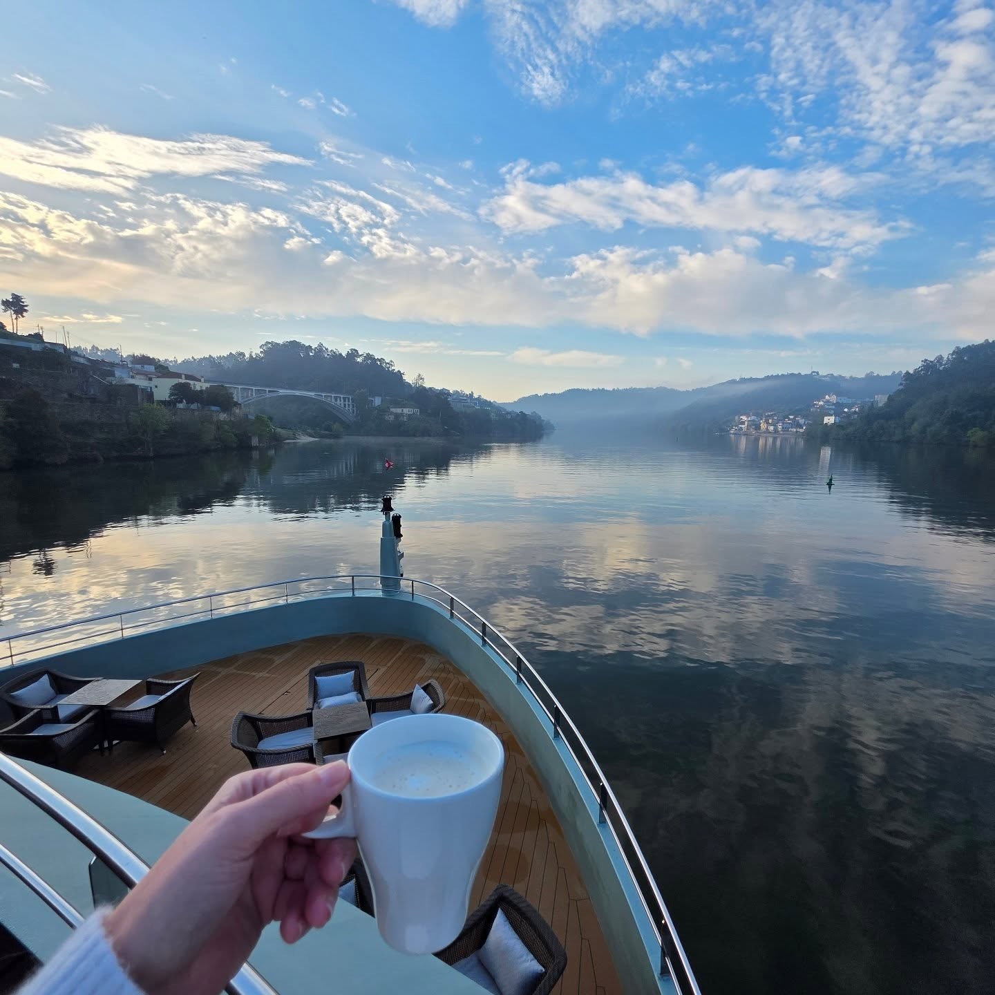 Coffee above a river ship’s bow in the Douro Valley
