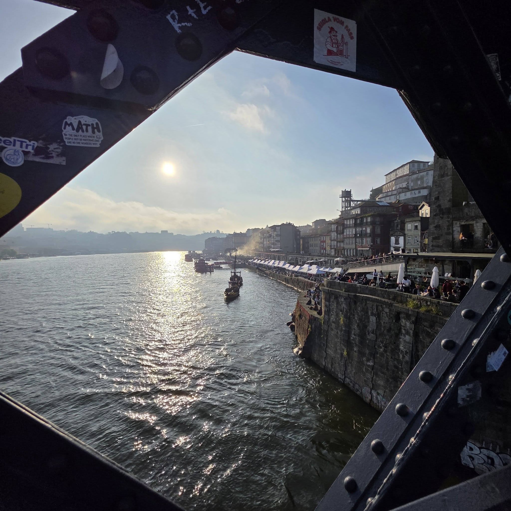 Porto’s riverside and boats seen through a circular metal window