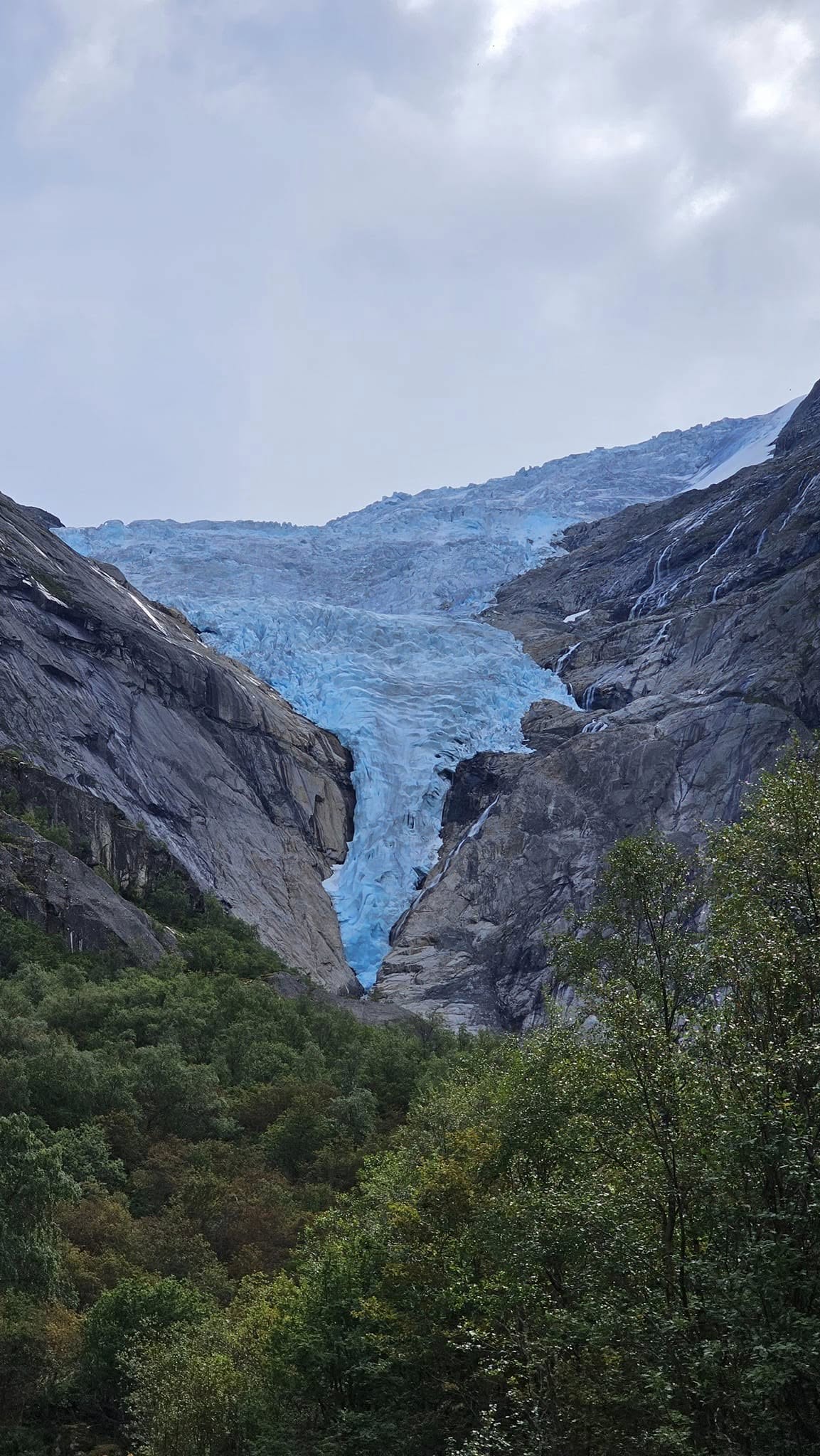 The blue ice of Briksdal Glacier between the mountains